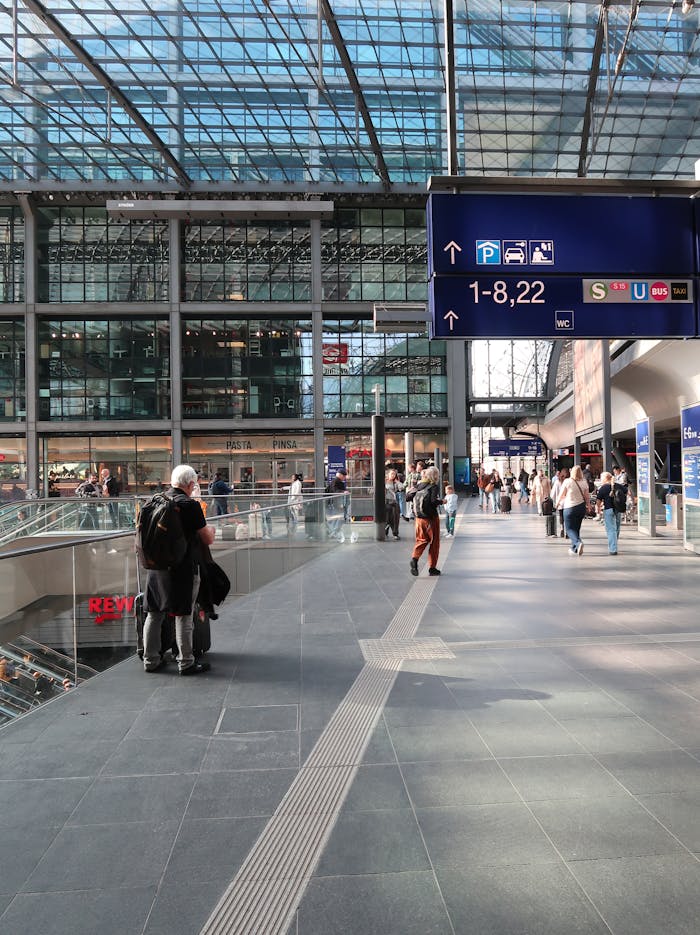 A bustling modern train station with people and signage, showcasing urban travel life.