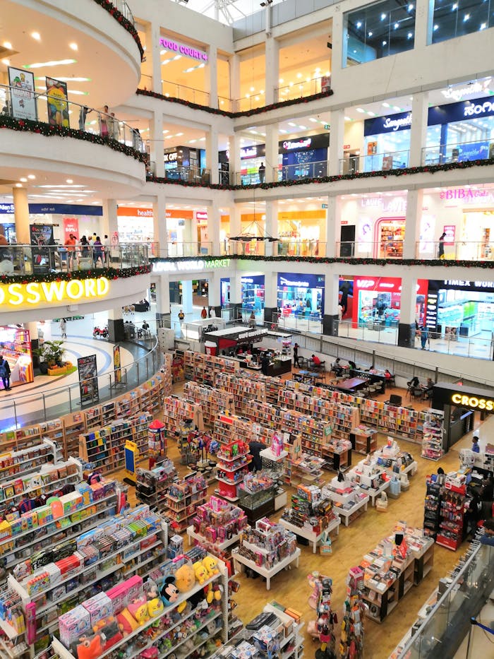 Bright daytime view of a bustling shopping mall with multiple stores and levels.